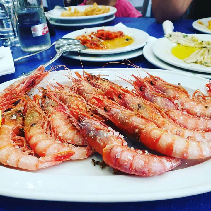Anuncio de un restaurante con su plato de gambas a la plancha en Marbella
